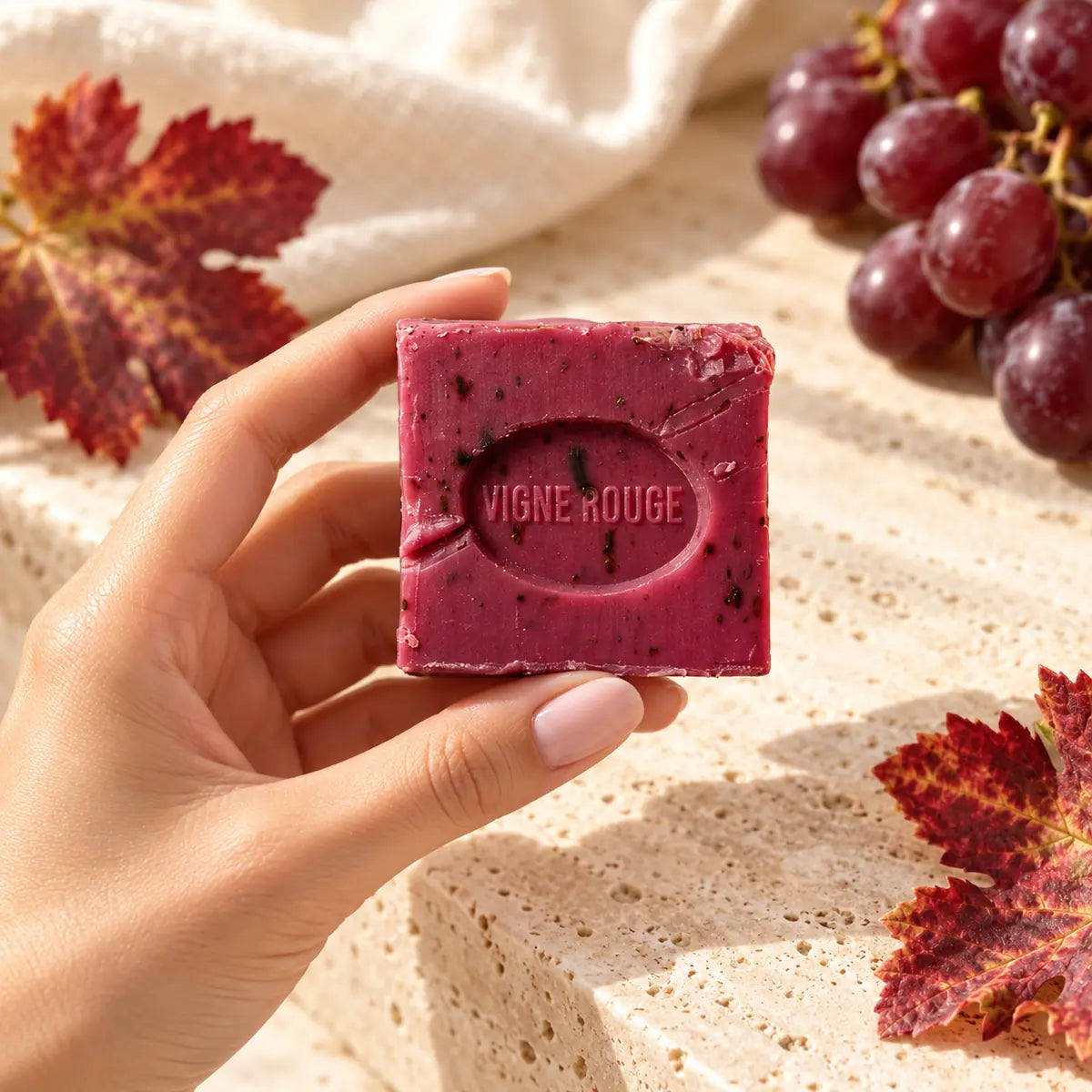 Jabón vegetal Vigne Rouge SOULBEAUTY sostenido en una mano